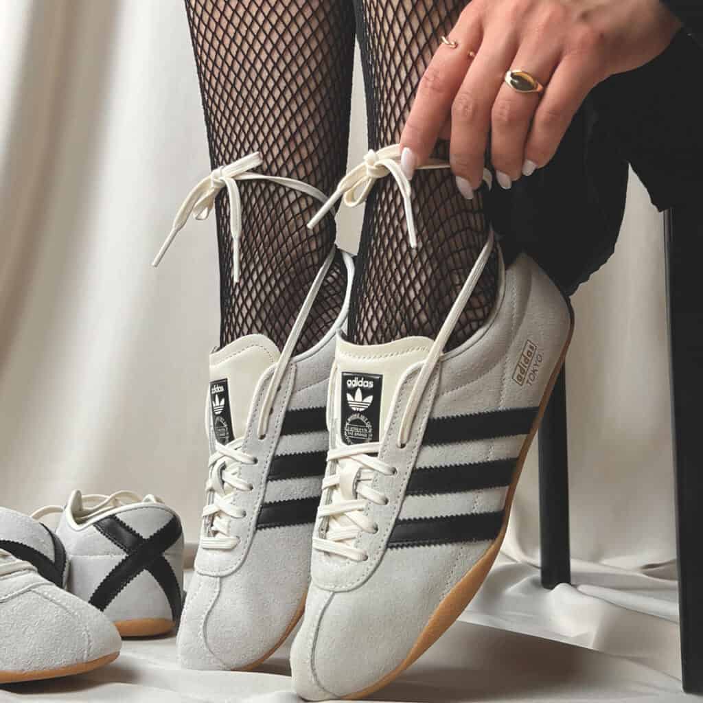 mulher calçando tenis adidas tokyo